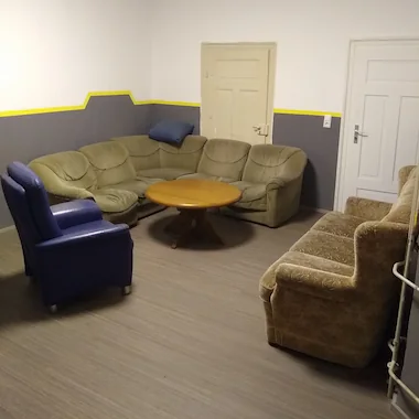 Das sogenannte Esszimmer. Raum mit Tisch und einigen Sofas 